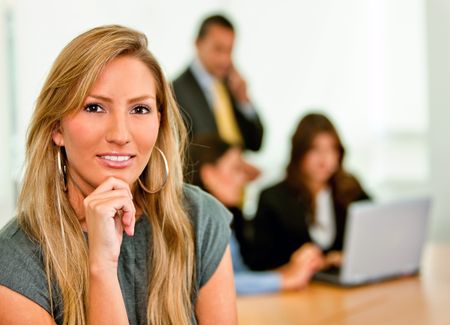 Business woman at the office with a group behind