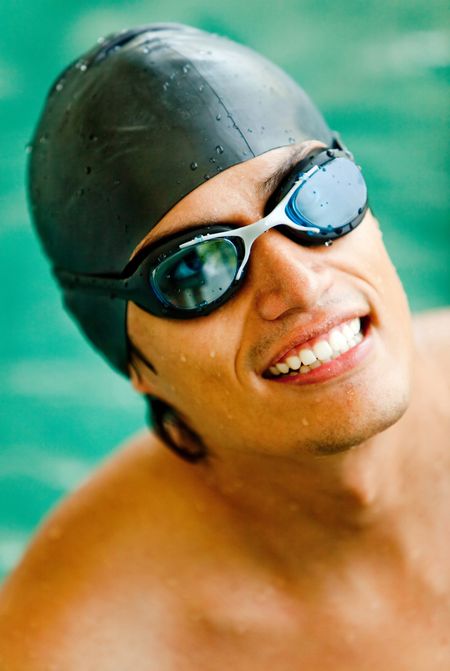 Professional male swimmer wearing a hat and goggles