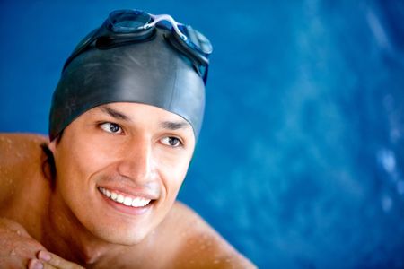Professional male swimmer wearing a hat and goggles