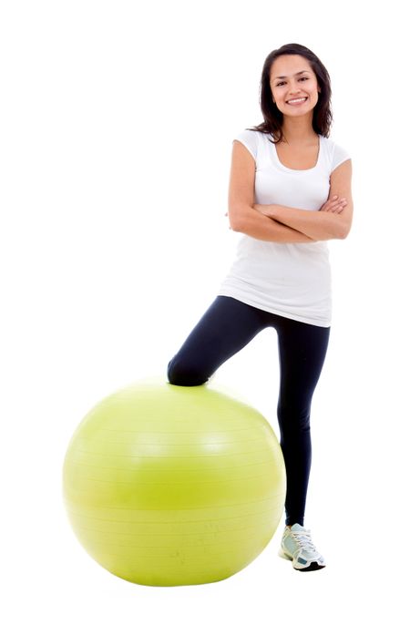Woman with a pilates ball isolated over a white background