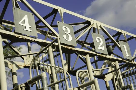 Numbers one through four atop old schooling gate on equestrian training track