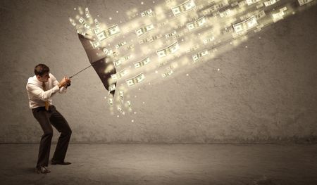 Business man holding umbrella against dollar rain concept on grungy background