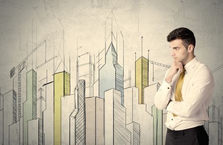 A young adult businessman standing in front of a wall with colorful drawings of buildings, charts, graphs, signs