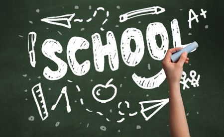 A teacher writing school, drawing children things on clean green chalkboard by hand