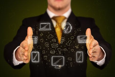 Businessman holding icons related to devices and communication