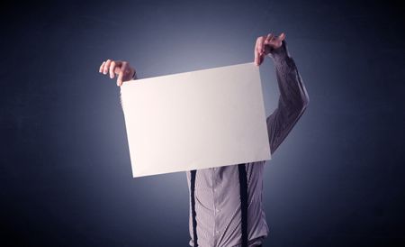 Young businessman hiding behind a blank piece of paper