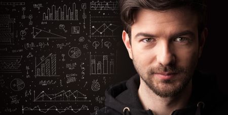 Portrait of a young businessman with charts and graphs scribbled next to him on a dark background