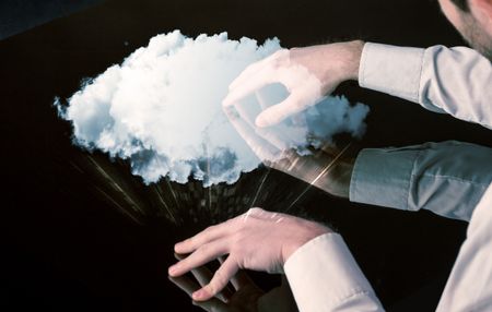 Male hands touching interactive table with a white cloud on it 