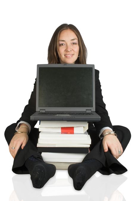 business woman sitting on the floor behind a laptop and some books