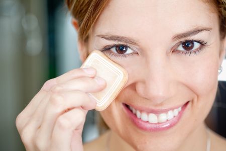 Beautiful woman powdering her face - make up concepts