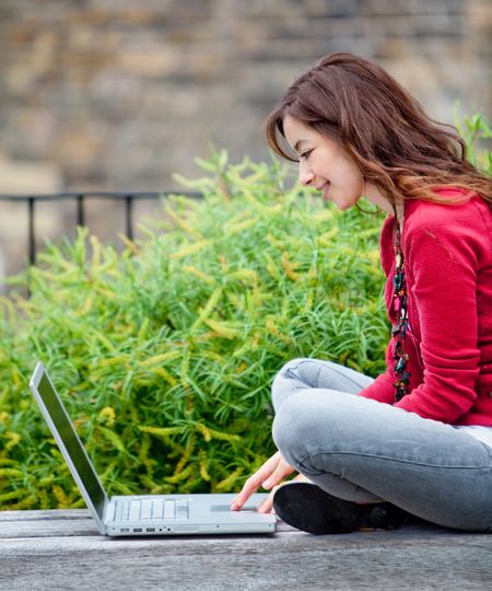 Young woman working on a laptop computer outdoors