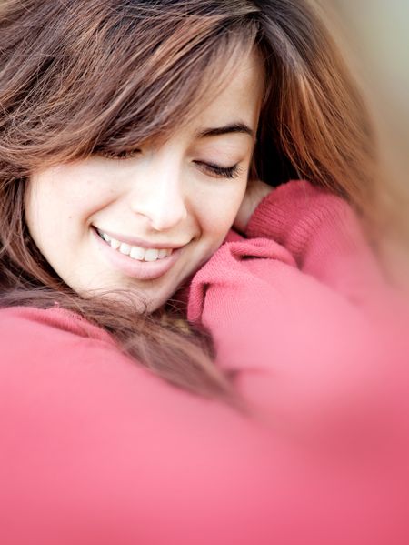 Portrait of a beautiful young woman cuddling and smiling