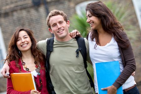 Happy group of students outdoors holding notebooks