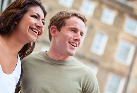 Portrait of a happy couple smiling outside their building