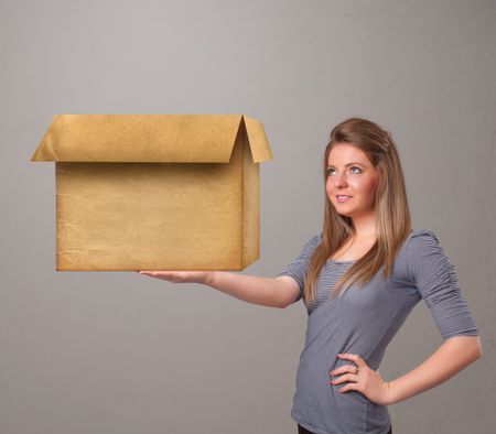 Beautiful young woman holding an empty cardboard box