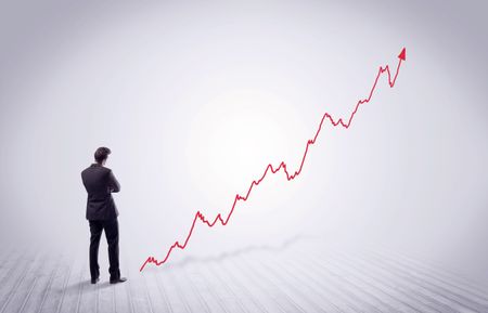 Elegant business person standing with his back looking at growing graph chart in space concept