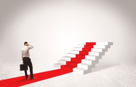 A successful businessman with briefcase standing on red carpet in front of steps in white space concept