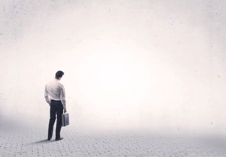 serious-business-man-standing-grey-brick-603586079 Serious business man standing on grey brick floor and thinging about decisions concept