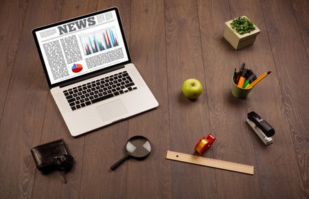 Computer laptop on wooden desk with office accessories 