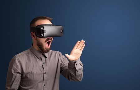 Amazed businessman with virtual reality goggles 
