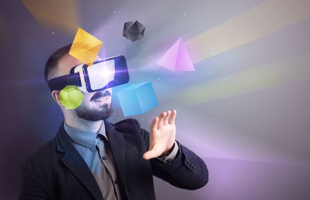 Amazed businessman with virtual reality colorful geometric shapes in front of him