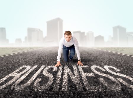 Young determined businessman kneeling before business text 