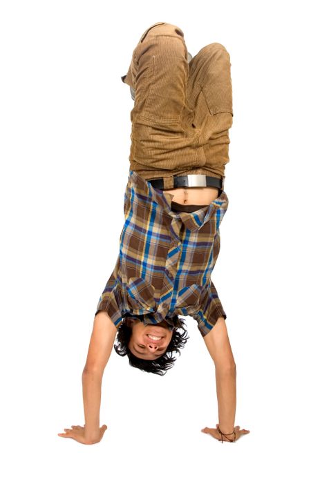 casual guy doing a handstand isolated over a white background