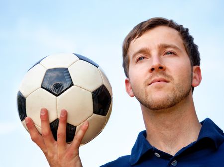 European man portrait holding a football outdoors