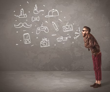 A funny hipster person in casual urban clothing shouting drawn everyday items like camera, tie or pen on city wall concept
