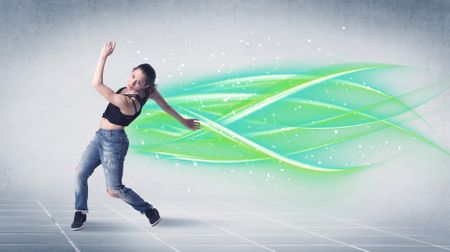 A good looking fresh street dancer dancing in front of grey background with white and bright, colorful green lines concept