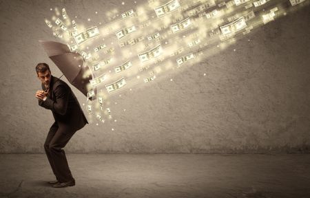 Business man holding umbrella against dollar rain concept on grungy background