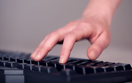 Close up of hand pressing keyboard buttons on desk