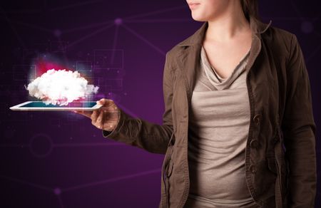 Casual young woman holding tablet with cloud concept and purple background 