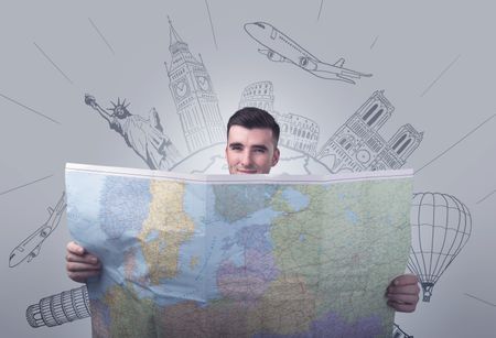 Handsome young man holding a map with famous sightseeing destinations above his head