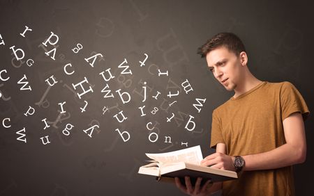 Casual young man holding book with white alphabet flying out of it