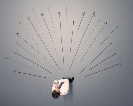 young-contemplating-businessman-stands-front-grey-608787116 Young contemplating businessman stands in front of grey arrows