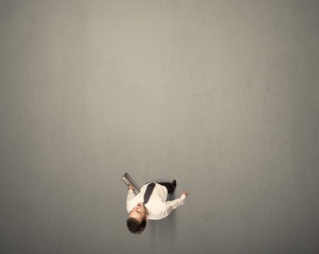 Young businessman contemplating a decision standing on a grey surface