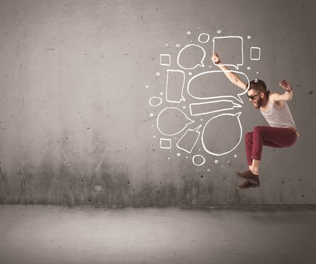 A comic hipster guy shouting in front of grey urban concrete wall with drawn empty text bubbles around his mouth concept