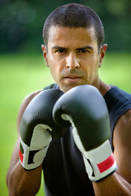 Portrait of a handsome male boxer outdoors wearing gloves