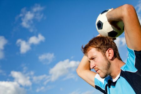 Portrait of a European man holding a football outdoors