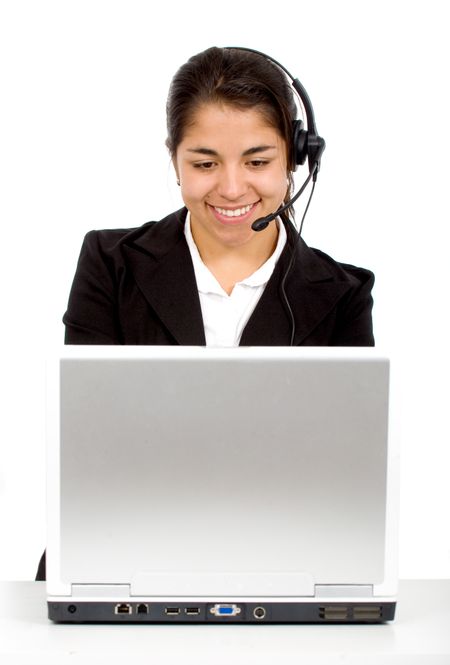 customer service girl at her desk on a laptop computer smiling - isolated over a white background