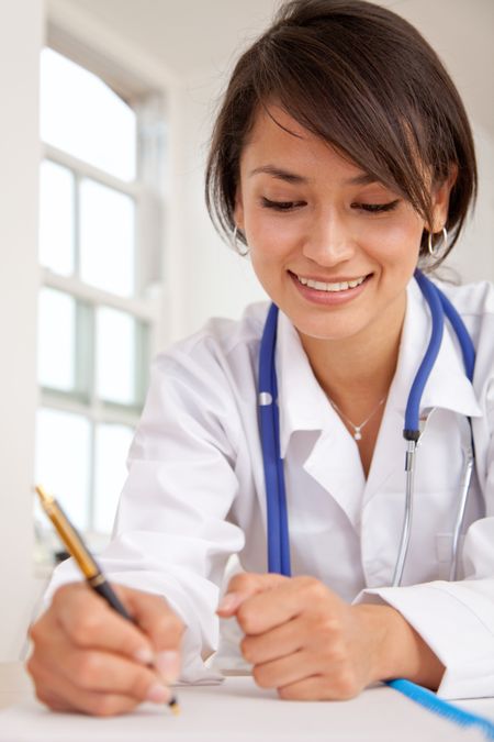 Female doctor at the hospital writing a medical history