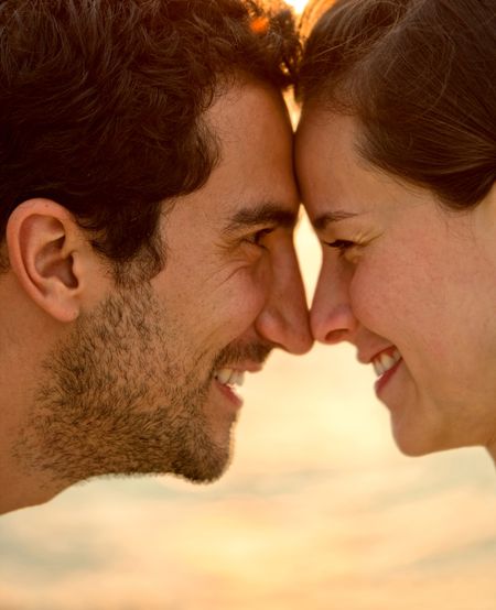 Beautiful loving couple with heads together at sunset