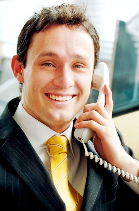 Business man on the phone smiling in an office