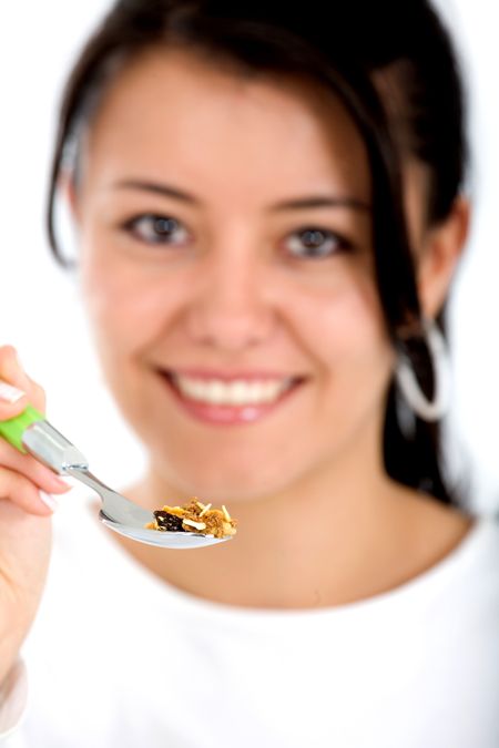 girl eating healthy cereal with a spoon isolated over a white background