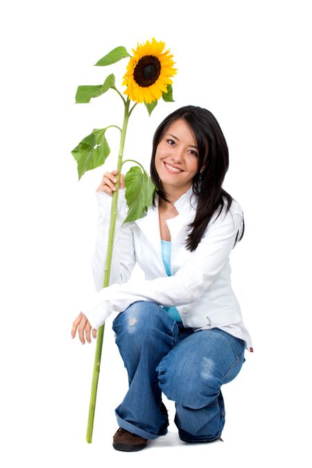 girl sitting down smiling while holding a sunflower isolated over a white background