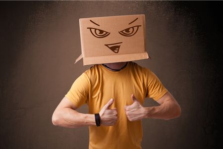 Young man standing and gesturing with a cardboard box on his head with evil face