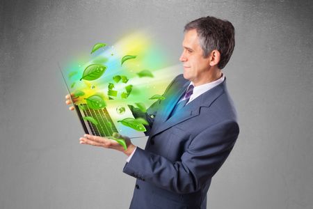 Handsome businessman holding laptop with recycle and environmental symbols