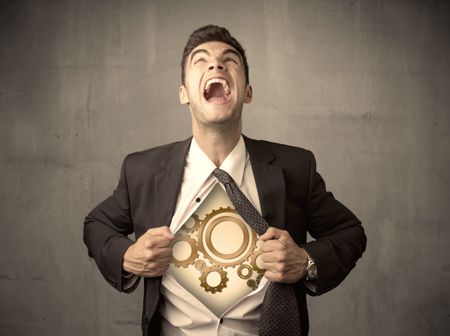 Businessman tearing shirt off and machine cog wheel shows on his chest concept on background