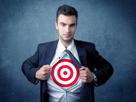 Businessman tearing his shirt off with target sign symbol on his chest concept on background
